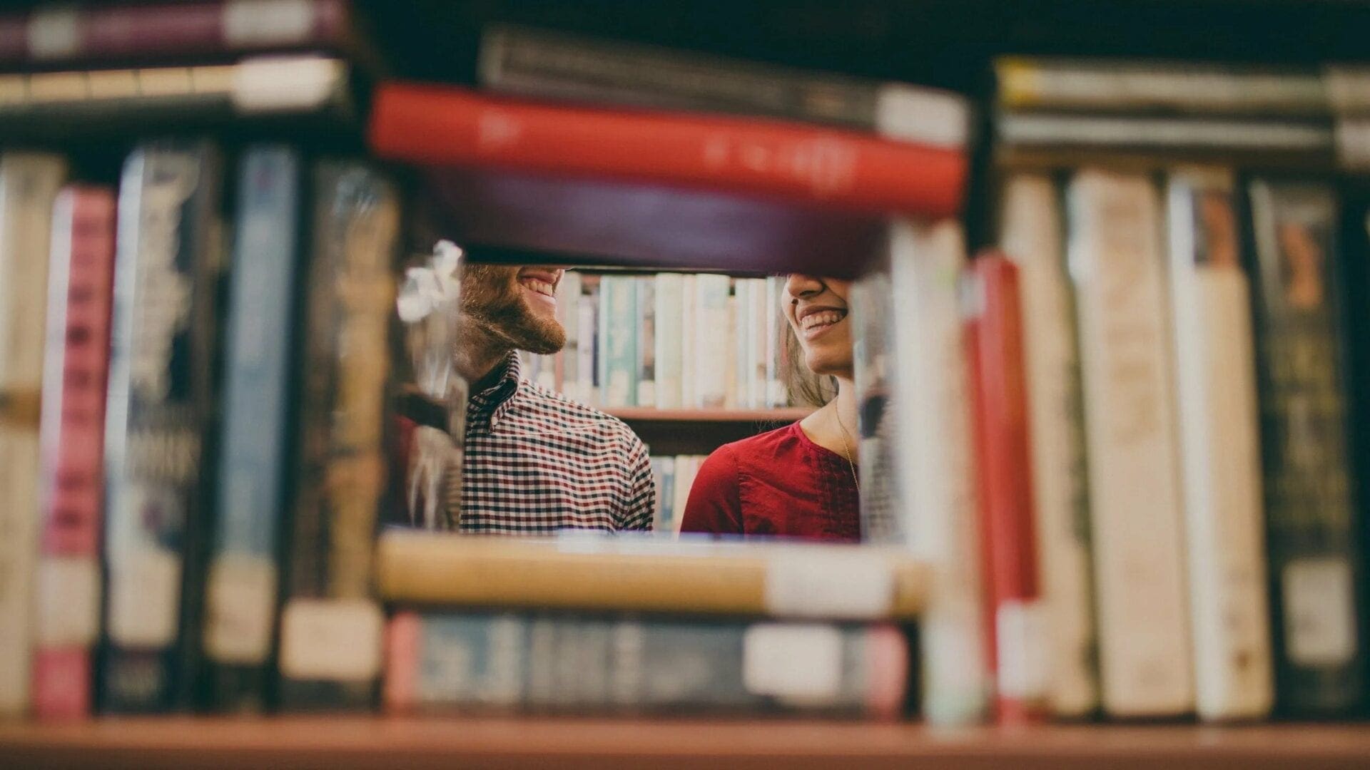 Two people sitting in front of a bookshelf