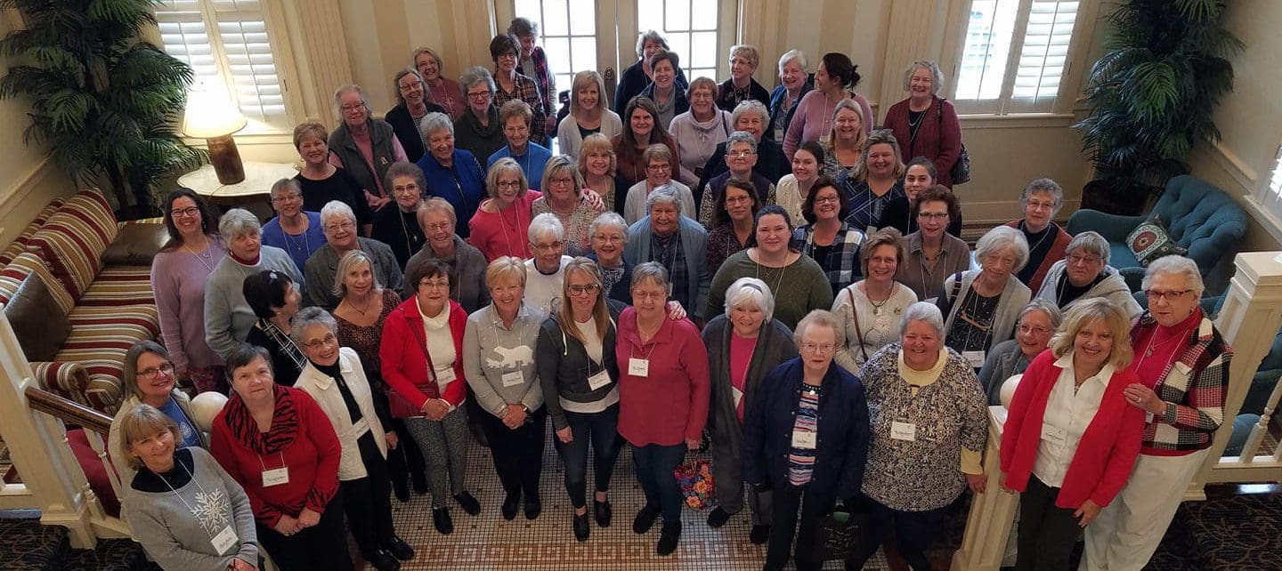 A group of women standing together in front of a door.