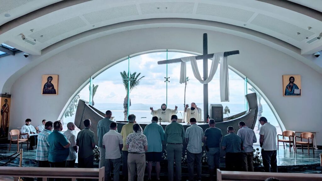 A group of people standing in front of a cross.