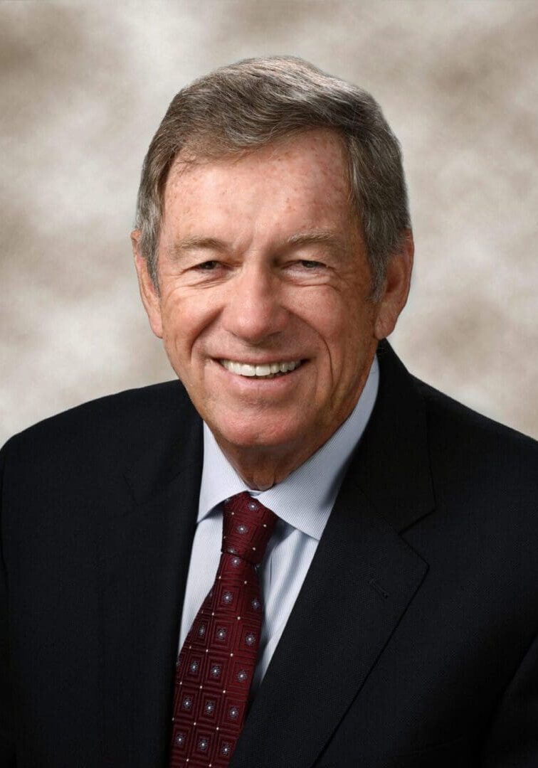 A man in suit and tie smiling for the camera.